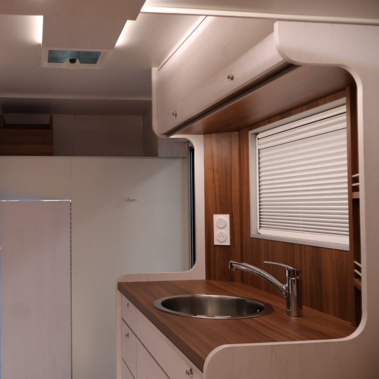 intérieur camion espace cuisine Intérieur d'une cuisine moderne avec un évier et des finitions en bois clair.